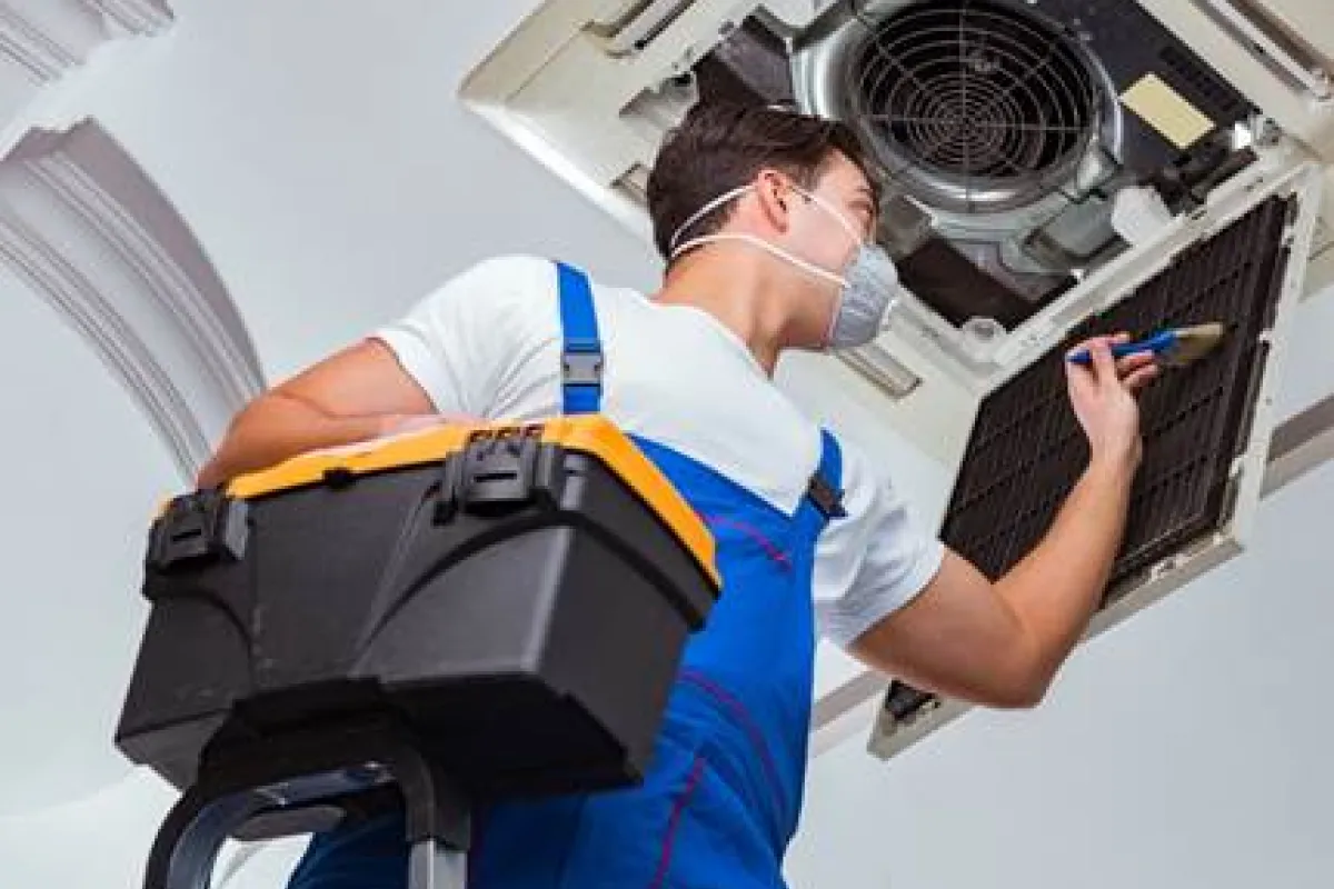 Instalador de aire acondicionado limpiando un filtro