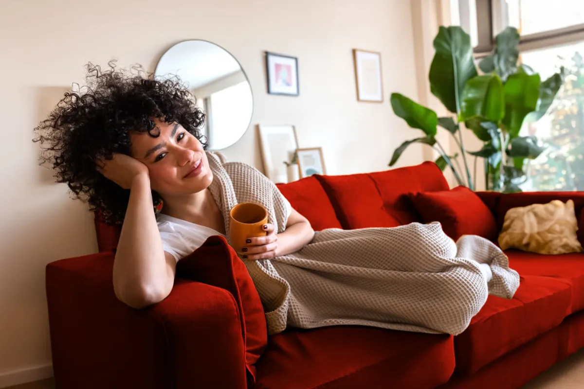 Una chica disfruta del aire acondicionado en un sofá