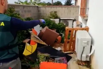 Imagen de un guardia civil señalando uno de los aparatos de aire acondicionado